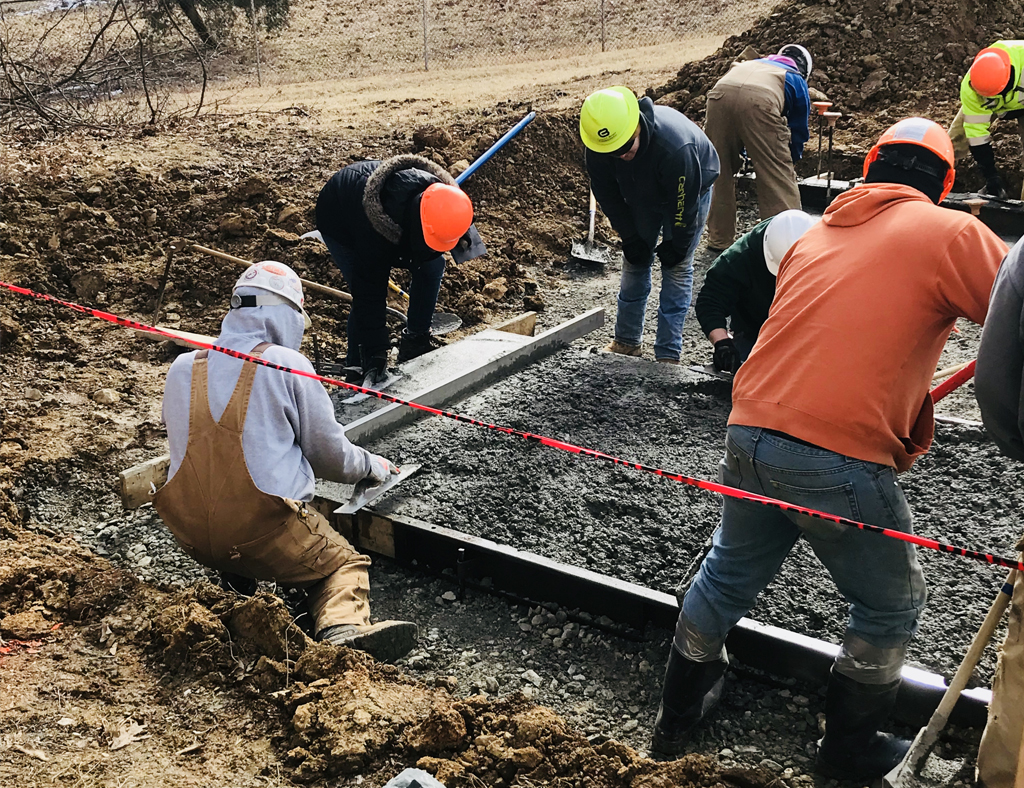 Laborers finishing a concrete pour on a job site