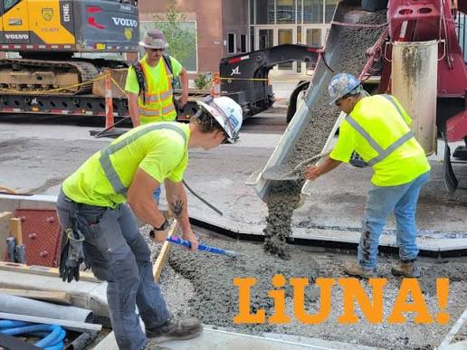 Laborers placing concrete with a pump truck